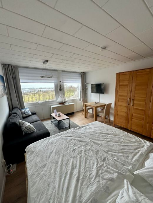 Wohn- und Schlafbereich mit Bett, Sofa, Esstisch und Fernseher
